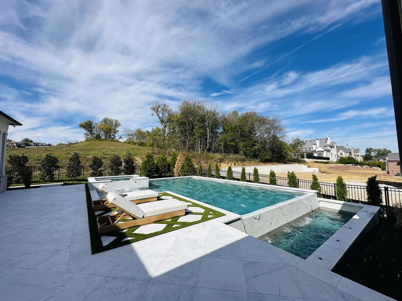 Infinity-edge pool with sun loungers overlooking a Kentucky hillside