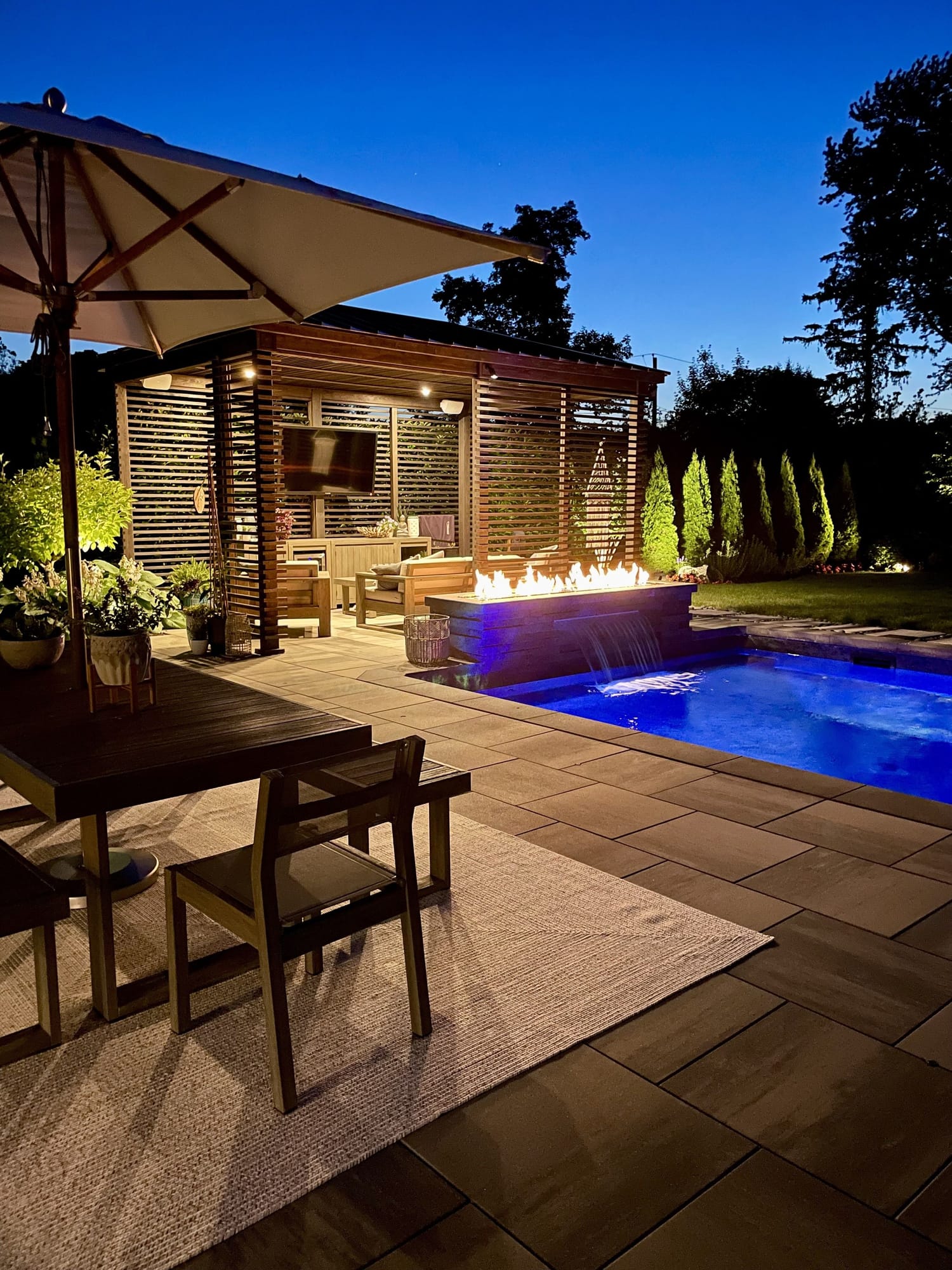 Pool and linear fire feature lit at dusk