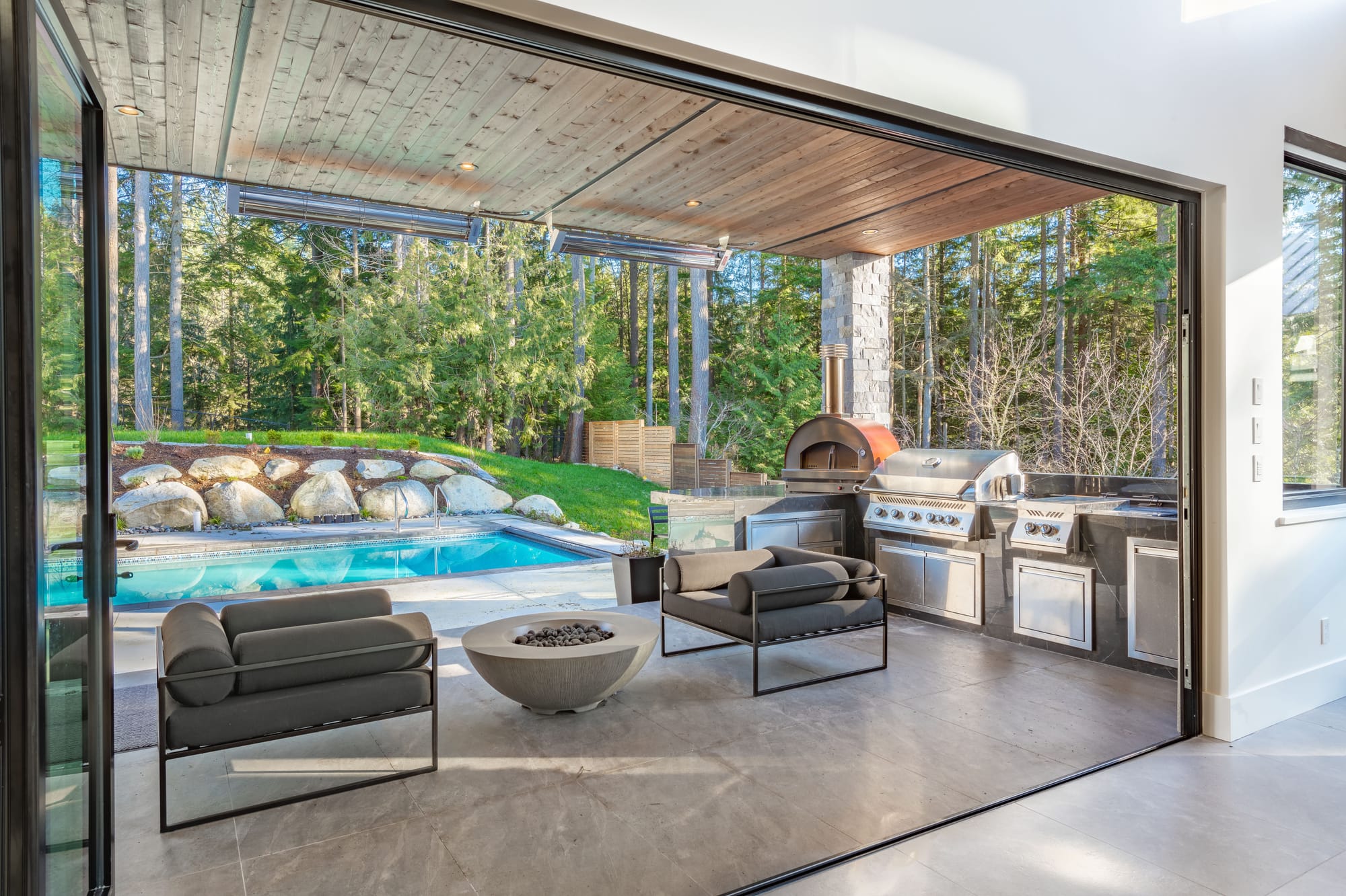 Covered patio with a built-in grill beside a pool